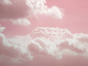 粉彩粉紅天空，有蓬鬆的白雲輕輕飄動。 — 美學雲朵 壁紙