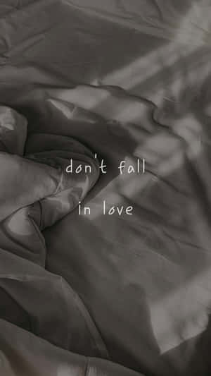 皺褶灰色布料上的文字疊加顯示 don't fall in love。 — 憂鬱美學 壁紙