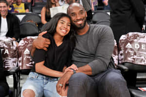 柯比·布萊恩與女兒吉安娜在籃球比賽中一起微笑。 — MacBook Air 15 壁紙