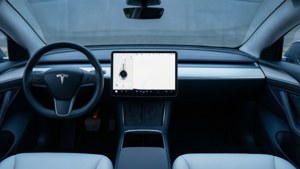 Tesla 汽車內部，配備簡約儀表板及大型觸控螢幕。 — 特斯拉 壁紙