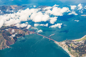 從上方觀看金門大橋，下方有雲朵和海洋
