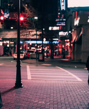夜間城市街道，有發光的霓虹燈招牌和紅色交通燈。 — 美麗的夜晚 壁紙