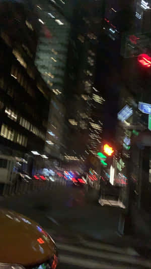 夜間城市街道，帶有模糊燈光和高樓大廈。 — 城市 壁紙