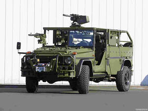 橄欖綠軍用吉普車配備武器，停放在白色牆前。 — Mercedes Benz C300 壁紙