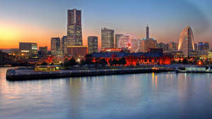 日落時分的橫濱港天際線，燈火通明的建築物和摩天輪。 — 東京鐵塔 壁紙