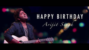歌手Arijit Singh在舞台上彈吉他，配有生日文字和彩色燈光。 — 音樂 壁紙