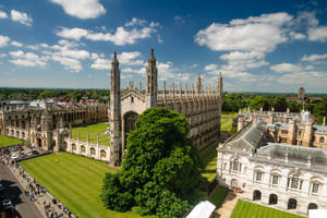 哥德式大學建築，綠色的草坪和樹木，藍天白雲。 — 英格蘭 壁紙