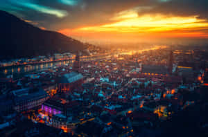 日落時的城市景觀，發光的建築物和河流倒映著金色的天空。 — 夕陽天空 壁紙