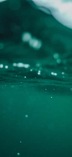 藍綠色水下場景，帶有上升氣泡和光線反射。 — Galaxy S25 壁紙