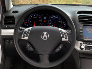 汽車內部視圖，顯示方向盤及帶有數位顯示螢幕的儀表板。 — Acura 壁紙