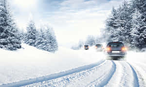 汽車在積雪的森林道路上行駛，兩旁是覆蓋白雪的樹木。 — 冬季風景 壁紙
