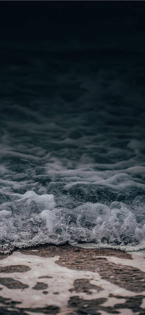 泡沫般的海浪在黃昏時分湧上深色沙灘。 — 波浪 壁紙