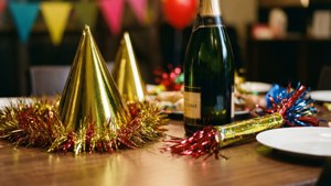 節日餐桌，配有香檳瓶、派對帽和亮片，用於慶祝。 — 新年 壁紙