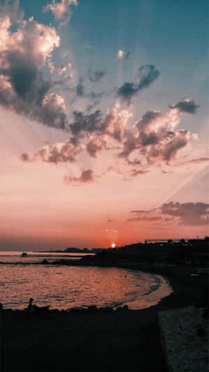 平靜海岸灣的日落，有粉紅色的雲彩和剪影般的懸崖。 — Vsco 壁紙