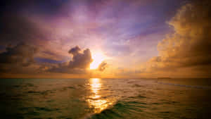 海洋上的日落，金色光線和紫色雲層。 — 暮光 壁紙