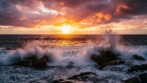 強勁的海洋日出，伴隨海浪與岩石，象徵力量與新的開始。 — 激勵 壁紙