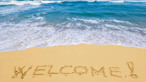 在海浪邊緣的沙灘上寫著WELCOME — 海灘 壁紙