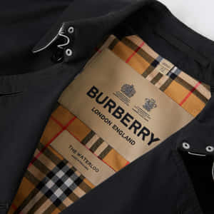 海軍藍色 Burberry 風衣，帶有格紋襯裡和可見的品牌標籤。 — Burberry 壁紙