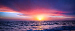 海上的日落，天空色彩繽紛，海浪輕柔 — 3440x1440 壁紙