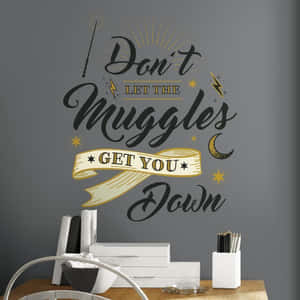 牆貼上印有哈利波特語錄「Don't Let The Muggles Get You Down」，位於一個有美術用品的桌子上方。 — 哈利波特 美學 壁紙