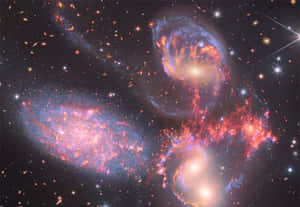 深空中色彩繽紛的星系和發光星雲的戲劇性景象。 — 星際效應 壁紙