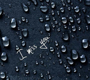 帶有水滴和手寫訊息「I miss you」的深色紋理表面。 — 我想你 壁紙