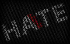 「hate」這個字的文字圖案在黑色背景上形成一個紅色心形。 — 字體排印 壁紙