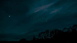 黑暗天空，星星和微弱極光在樹木剪影上方 — 黃色美學 GIF 壁紙