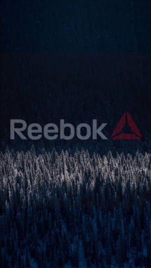 Reebok 標誌在黑暗冬季森林的雪松樹上方。 — 銳步 壁紙