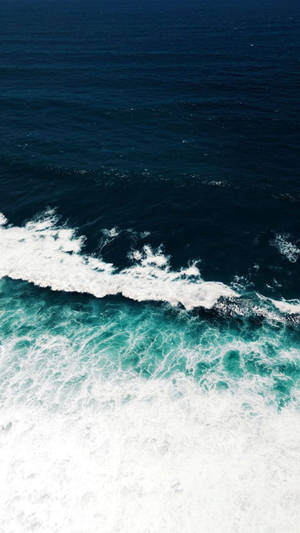 海浪在綠松石色水中破碎並帶有白色泡沫的航拍視圖。 — 海洋 壁紙