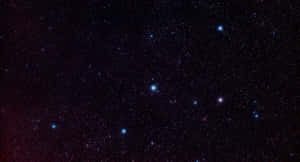 繁星點點的夜空，有發光的星星和微弱的紅色星雲。 — 星星 壁紙