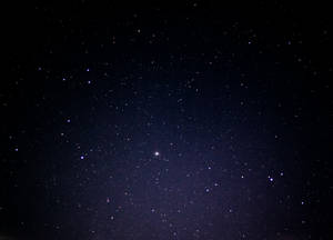 一個繁星點點的夜空，遠處有一個明亮的星體在發光。 — 高解析度 壁紙