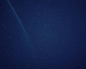 一顆帶有發光尾巴的彗星劃過繁星點點的夜空。 — 藍天 壁紙