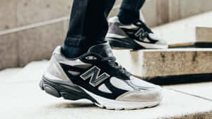 人在混凝土樓梯上穿著黑白New Balance運動鞋。 — New Balance 壁紙