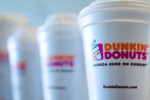 一排Dunkin' Donuts咖啡杯，標誌清晰對焦。 — Dunkin Donuts 壁紙