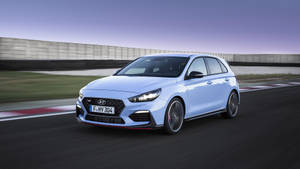 淺藍色現代 i30 N 在暮色中的賽道上疾馳。 — Mercedes Benz C300 壁紙