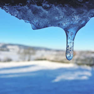 在清澈藍天下，融化的冰柱懸掛在雪地上方。 — 背景 壁紙