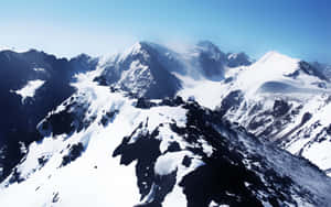 積雪的山脈，山峰尖銳，天空清澈湛藍。 — 冬季風景 壁紙