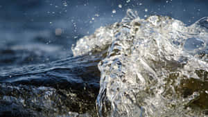 水滴懸浮在空中，水花濺到岩石上。 — 界王拳 壁紙