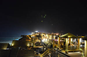 以海洋為背景，照明木製海濱用餐建築的夜景。 — 喀拉蚩 壁紙