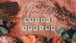 三月日曆，帶有「Hello Spring」拼字遊戲字母牌和粉紅色布料上的鮮花。 — 三月 壁紙