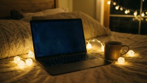 MacBook在一個溫馨的房間裡，配有仙女燈和咖啡。