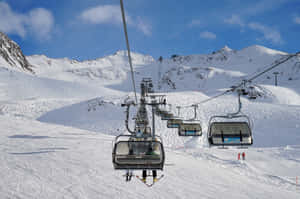 滑雪纜車在清澈藍天下攀升於積雪的山坡。 — 冬季風景 壁紙