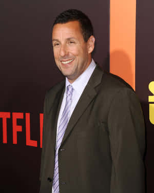 亞當·山德勒穿西裝在Netflix活動中微笑 — 4:5 壁紙