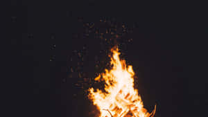 明亮的營火在漆黑的夜晚燃燒，火花四濺。 — 淺色 壁紙