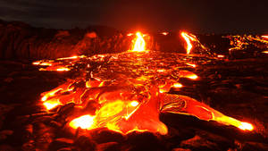 熔岩流和噴發在夜間照亮了黑暗的火山景觀。 — 自然 壁紙