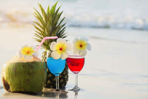 沙灘日落時分，熱帶飲品配上雞蛋花和鳳梨 — 日落 壁紙