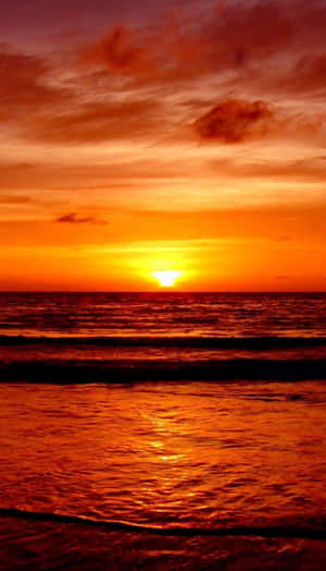 夕陽映照海洋，橙色和紅色的波浪向岸邊翻滾 — 海灘日落 壁紙