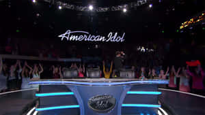 American Idol評審桌，電視錄影棚內有歡呼的觀眾。 — OLED 壁紙
