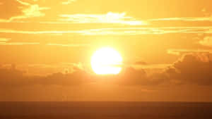 海洋上的夕陽與金色雲彩 — 橘色 壁紙